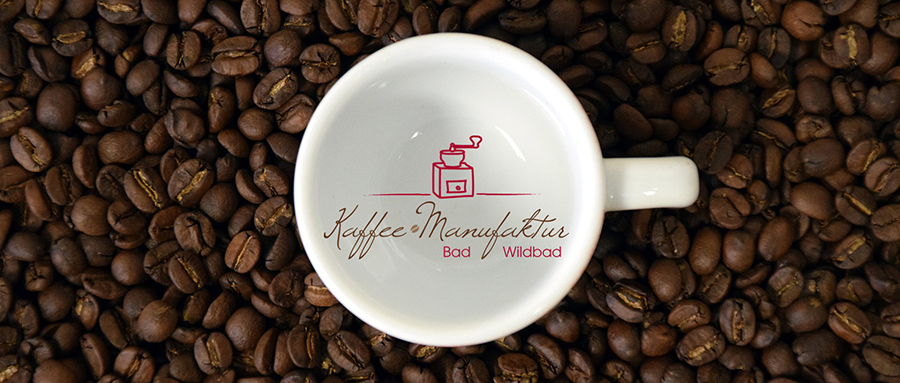 Kaffeebohnen mit einer Kaffeetasse von oben mit dem Logo der Kaffeemanufaktur Bad Wildbad